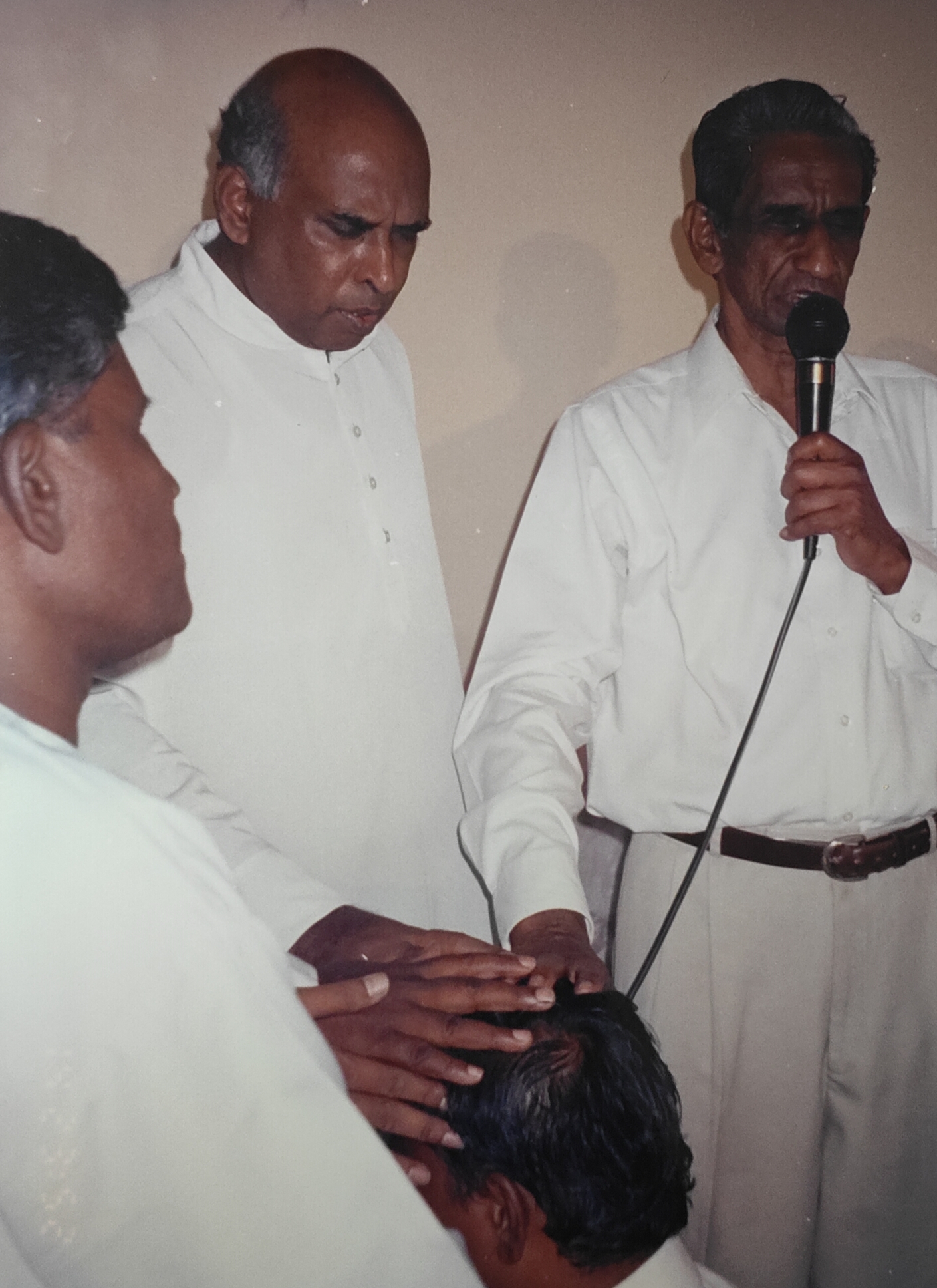 Elders laying hands in prayer